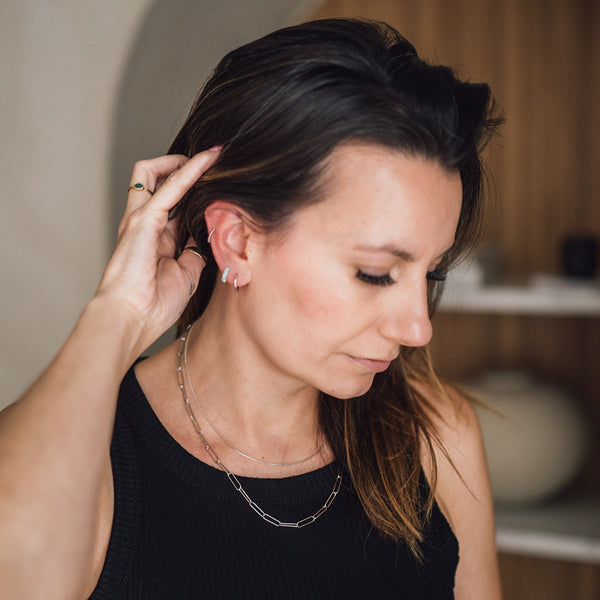 Assorted handcrafted earrings, necklaces, and bracelets displayed on a Owner, Leah.