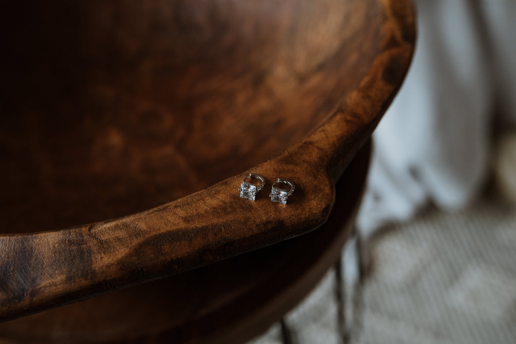 Pair of silver earrings on a wooden surface