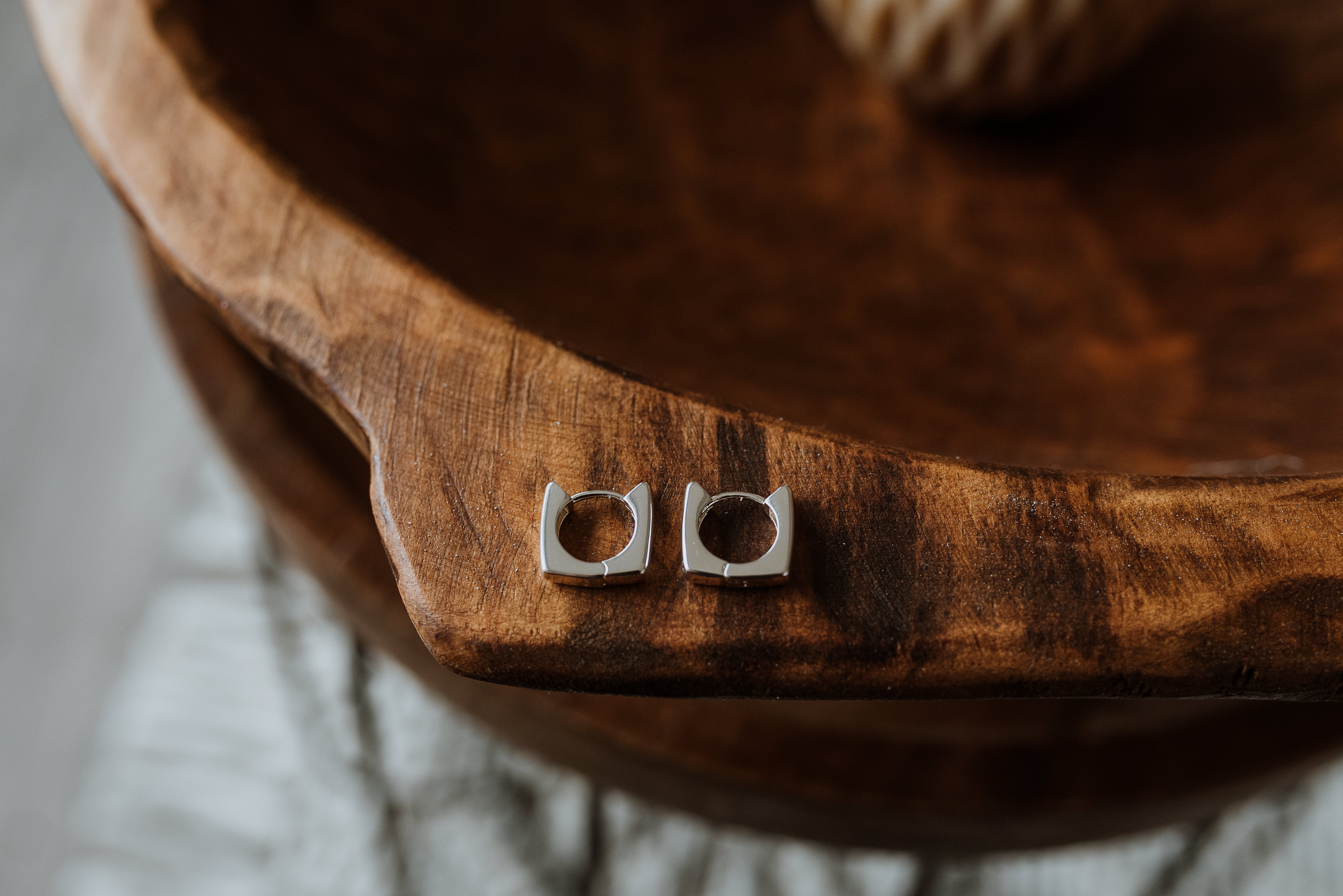 Silver earrings on a wooden surface