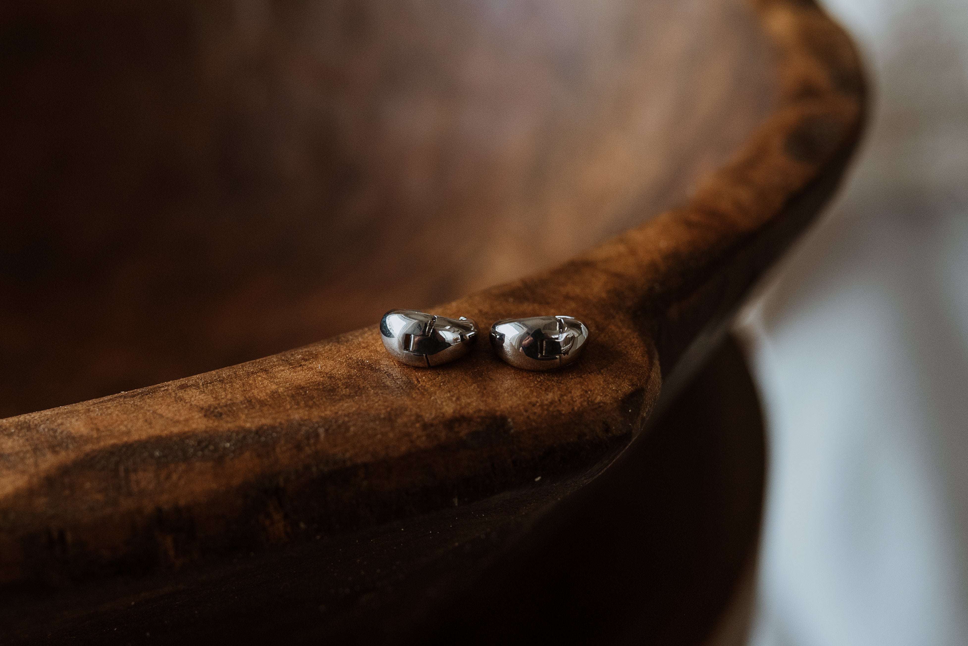 Silver earrings on a wooden surface