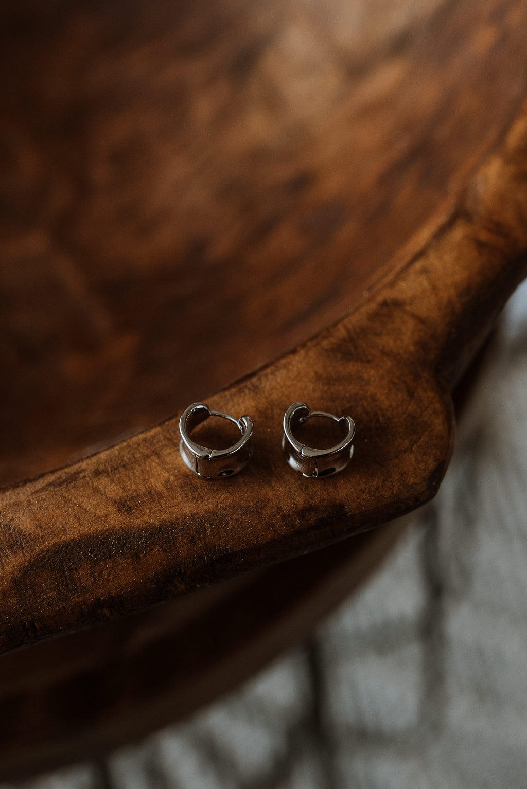 Silver hoop earrings on a wooden surface