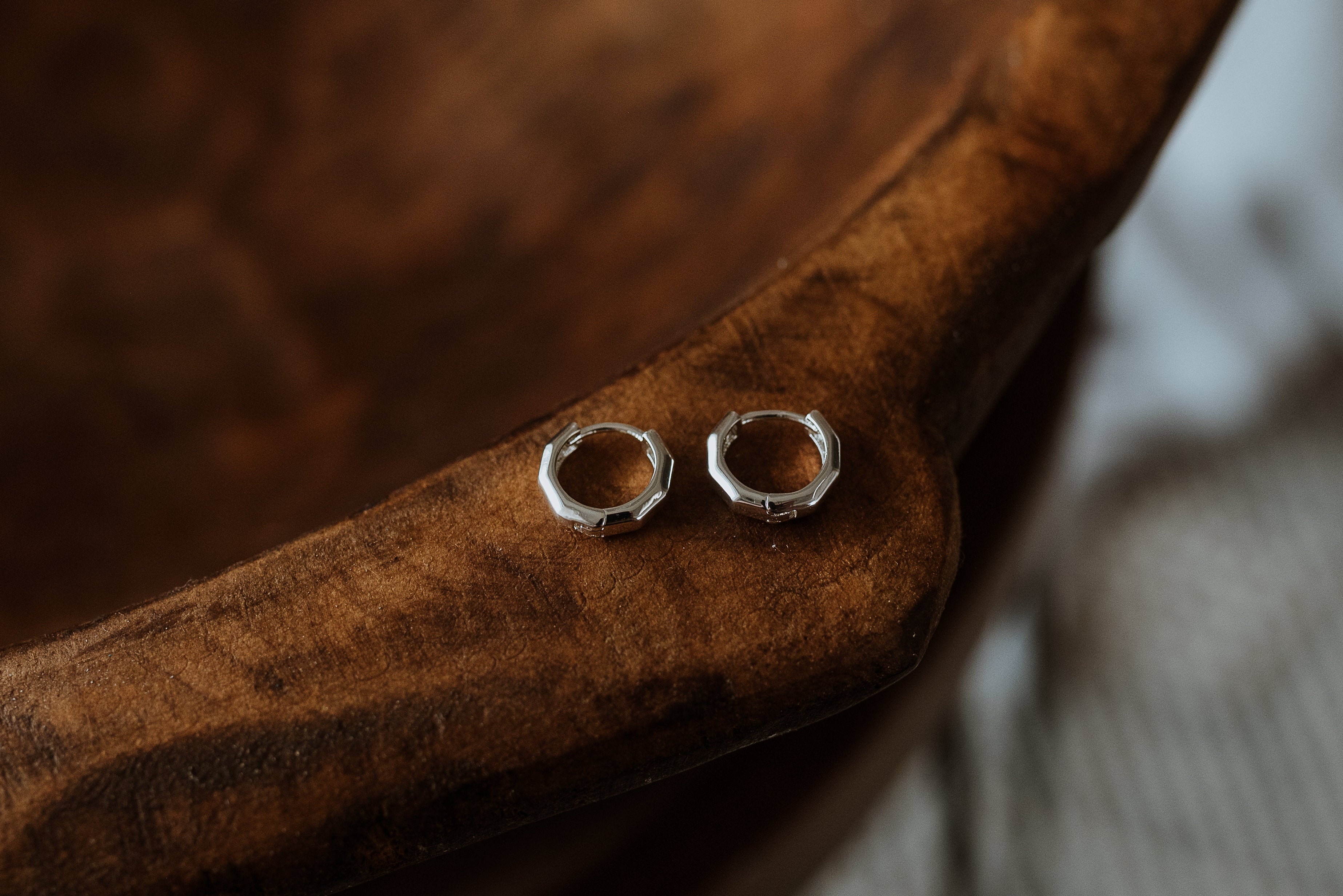 Silver hoop earrings on a wooden surface