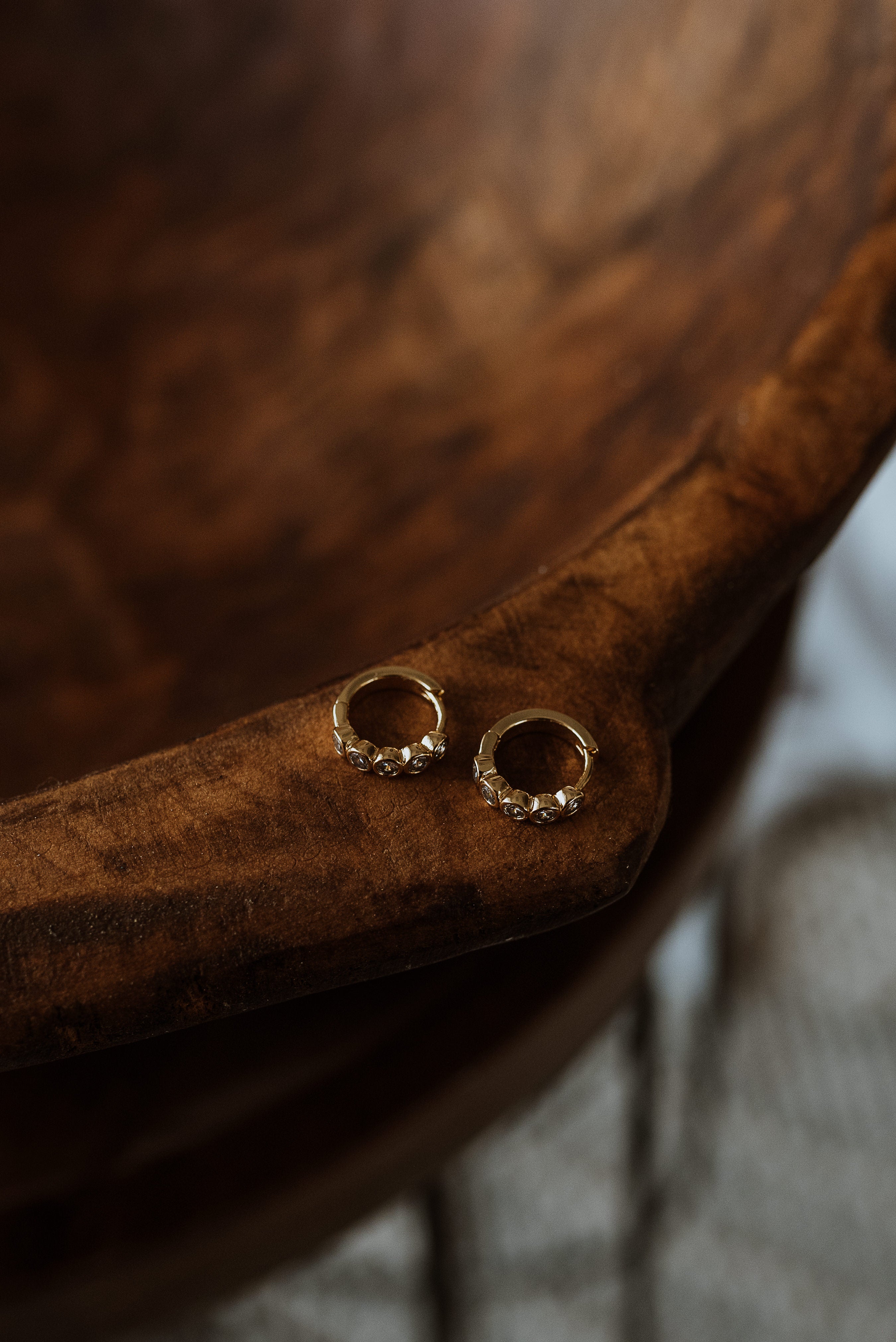 Gold earrings on a wooden surface