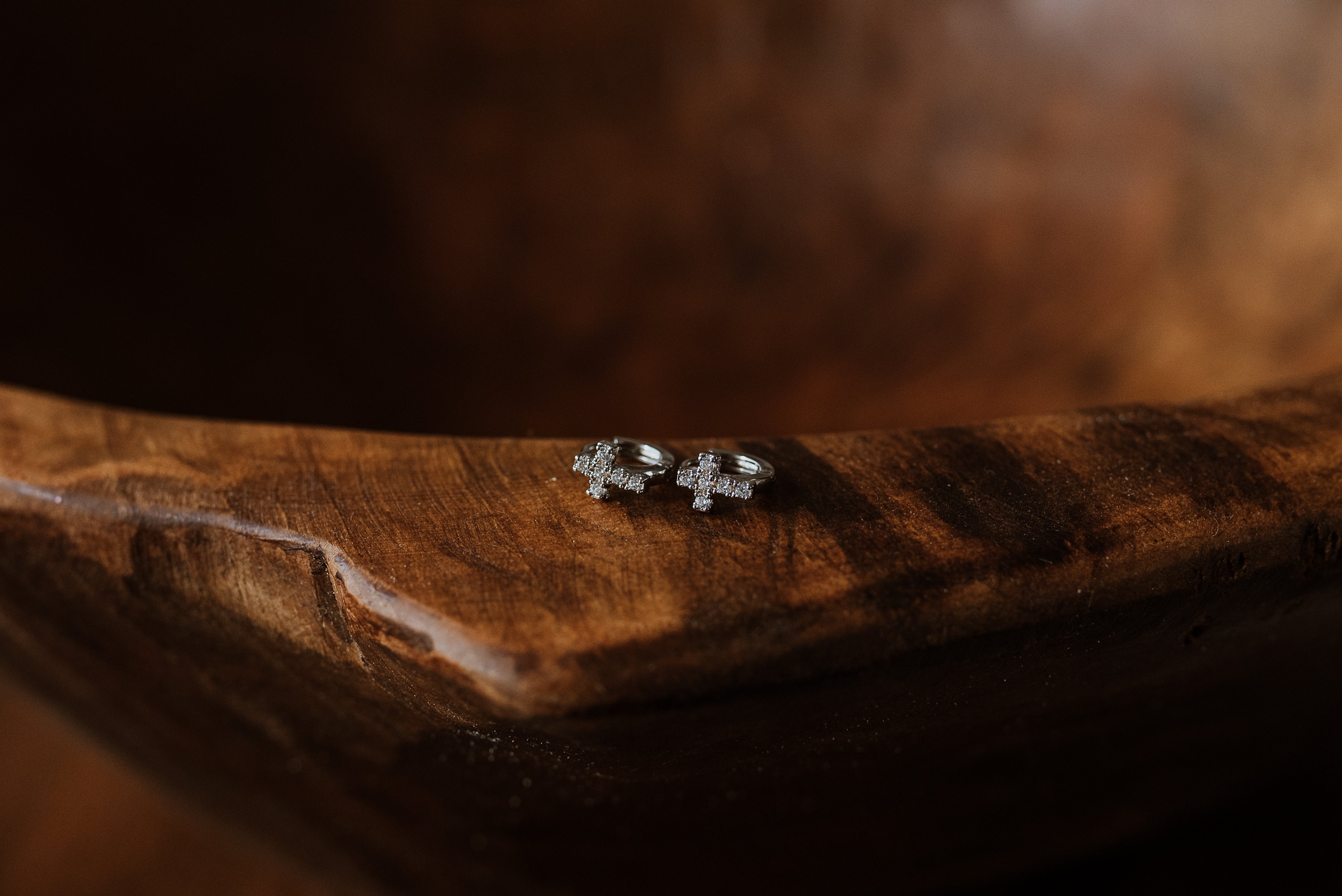 Pair of cross earrings on a wooden surface